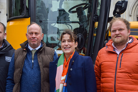 Victoria Atkins (c), Shadow Secretary of State for Environment, Food and Rural Affairs, stands with farmers next to a tractor outside the Royal Courts of Justice as they launch a legal challenge against the government's inheritance tax reform.