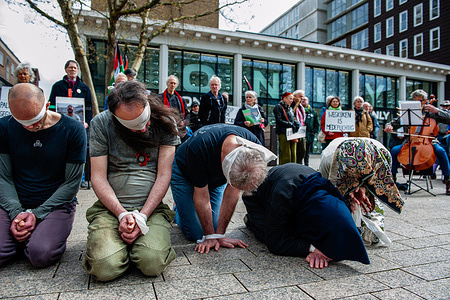 Participants are on their knees performing as Palestinian hostages. Activists performed as the Palestinian hostages held by the Israel government during a silent procession through the city to demand their release and against Israel's new execution law. With this protest, Nijmegen for Palestine wants to draw attention to the Palestinian hostages, who are often held for months, even years, without charge in appalling Israeli detention camps.