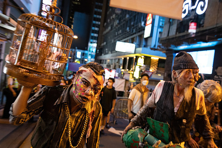 People wearing masks pose for photos during the Halloween celebration.