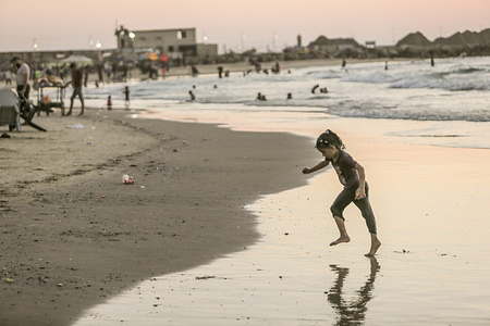 A Palestinian child plays at the beach on a hot day in Gaza City.