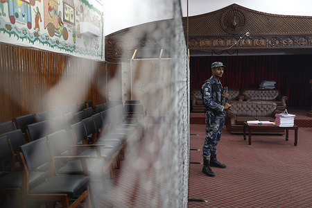 An Armed Police Force personnel stands on guard at a vote-counting station, a day ahead of the elections, at the Election Commission office in Kathmandu.