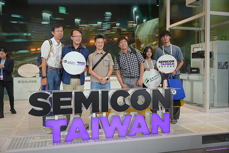 Visitors hold SEMI and SEMICON Taiwan signs during the semiconductor industry exhibition in Taipei.The group is photographed inside the exhibition venue during the industry event. SEMICON is a major global semiconductor exhibition held from September 2 to 4, 2026.