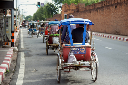 Foreign tourists seen riding traditional cycle rickshaws along the historic Old City wall. Once a common means of transportation, cycle rickshaws have become a popular cultural tourism attraction offering visitors a unique way to explore the city's historic landmarks while helping preserve one of the traditional occupations.
