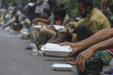 Poor people seen receiving food from Dhaka University Students food distribution during the nationwide lockdown.