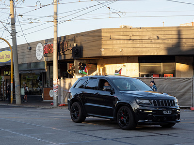 A vehicle displaying Palestian flags drives past the remains of Burgertory Caufield After a Burgertory chain-restaurant owned by Palestinian-Australian Hesham Tayah burned overnight in Melbourne's most-Jewish suburb, Pro-Palestine protesters gathered in a nearby park where violent exchanges occurred with pro-Israel counter-protesters. Police deployed pepper spray on both sides and made one arrest.