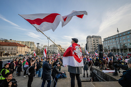 Wearing a small Belarusian flag around his shoulders, a man waves a much larger flag. On the afternoon of Sunday, the 29th of March, Belarusians in Warsaw gathered to celebrate Belarus Freedom Day with a march from Three Crosses Square to Castle Square in the old town. The participants marched with flags, banners, and a long Belarusian flag carried by those in attendance. Opposition leader Sviatlana Tsikhanouskaya and the Deputy Head of the United Transitional Cabinet of Belarus, Pavel Latushko, led the procession.