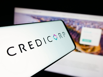 In this photo illustration, a smartphone with the logo of Peruvian financial holding company Credicorp is seen on screen in front of website.