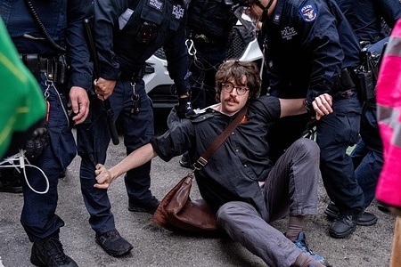 NYPD struggle to arrest a protester sitting in front of the van. A pro-Palestine rally was held today in front of The New School to “protect the last remaining encampment in New York”. The encampment was set up Wednesday night by New School faculty in the lobby of one of the schools’ academic buildings on Fifth Avenue. The protest ended in several arrests, including two counter protesters who were arrested for spraying mace at several protesters.