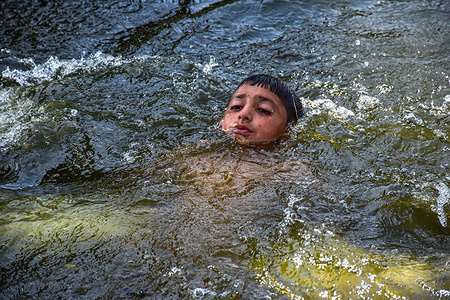 A Kashmiri boy cools off in the world-famous Dal Lake during a hot summer day. Kashmir recorded a temperature of 37.4 degrees Celsius after 72 years, which was the hottest day of this season. Climate change, temperature, and prolonged dry spells in Kashmir broke many records this year.