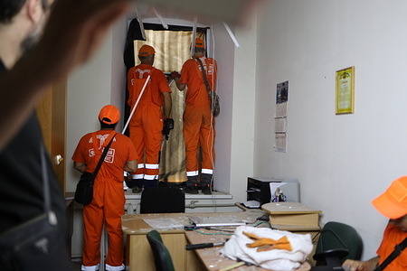 Workers cover damaged windows of Odessa Professional Lyceum of Maritime Transport on Primorskaya Street. A Russian missile attack damaged the Odessa Professional Lyceum of Maritime Transport on Primorskaya Street. City authorities reported no casualties.