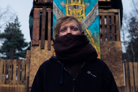 An activist poses for a portrait in front of the Leith Hill Camp fortress. In 2013, the fracking industry started casting a shadow over Great Britain; as a result, a patchwork of anarchist
groups has risen from the outskirts of society to protect the land and water.
In Northwestern England, they are organised in an effort to prevent the installation of the first commercial fracking operation
of the country in Preston New Road, Blackpool. Caught between the violence of security workers and police repression, the
anti-fracking protestors are struggling to maintain a pacifist philosophy eroded by daily protests and confrontations.
Meanwhile, perched in a lush Surrey forest, the Leith Hill fortress is watching over an other prospective site. Activists set up
camp there late October 2016 to prevent an exploratory drilling by Europa Oil & Gas Company. They've been on high alert ever since, weathering a legal injunction and an eviction, but they're now starting to show signs of fatigue and isolation.