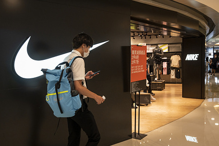 A young shopper walks past the American multinational sports clothing brand Nike store in Hong Kong.