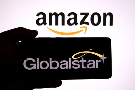In this photo illustration, a Globalstar logo is seen displayed on a smartphone with an Amazon logo in the background.