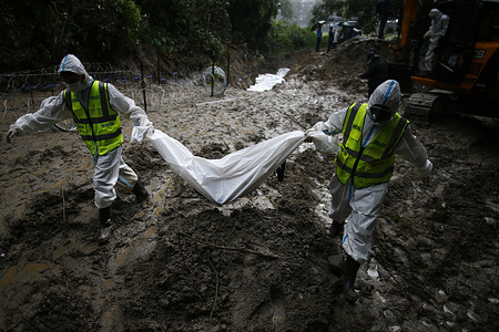 (EDITORS NOTE: Image depicts death) 
Security personnel carry a body of unidentified flood victim at a temporary burial site at Gokarna. Authorities have begun to temporarily bury unidentified remains, recovered from the devastating floods. DNA samples, photographs, and other identifying information are being collected before burial so families can later reclaim the remains of their people for final rites. The disaster killed more than 1,000 people in Nepal, with thousands still missing.