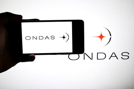 In this photo illustration, an ONDAS logo is seen displayed on a smartphone and in the background.