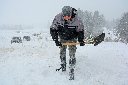 An off-road club member digs a rut into a severe blizzard.