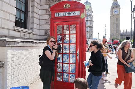 People seen near Smurfs in a red telephone box in Westminster, London ahead of their big screen return — the new animated musical reboot (starring Rihanna as Smurfette) which will hit UK cinemas on July 18, 2025.