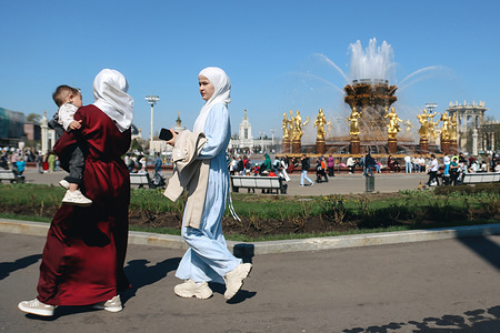 People walking against Fountain of Friendship of Peoples at the VDNKh.