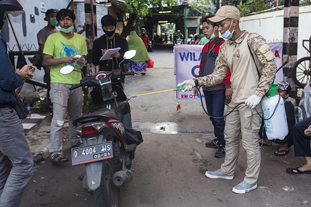 A resident disinfects the entrance to a housing complex while wearing a face mask as a preventive measure, during the corona virus pandemic.
The Jakarta administration has enlisted local authorities as part of wider efforts to curb the spread of the SARS-CoV-2 virus in the capital, which is the national epicenter of the epidemic that has infected more than 1600 people nationwide and killed 157