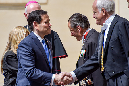 US Secretary of State Marco Rubio (L) is greeted by the Vatican ceremonial staff at the San Damaso Courtyard for an official meeting with Pope Leo XIV at the Vatican on May 7 2026US Secretary of State Marco Rubio arrives at the Vatican for a high level diplomatic visit and an official meeting with Pope Leo XIV to discuss international relations and global peace.
