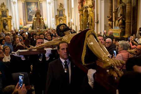 Members of the brotherhood carry the Christ figure, and behind it, the image of Our Lady of the Angels is carried on their shoulders as the procession leaves the church during the transfer of the image of Christ of the Halberdiers to the Royal Palace, for preparations for the procession that will take place through the streets of Madrid next Good Friday. Organized by the Congregation of the Holy Christ of Faith, Christ of the Halberdiers and Mary Immaculate Queen of the Angels.