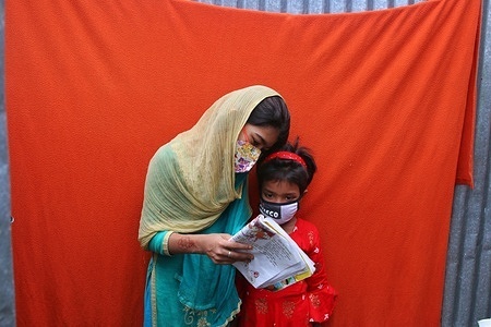 Slum girls reading a book while wearing face masks as a precaution during the Coronavirus pandemic at Korail slum.
The biggest slum in the capital of Dhaka, Korail has almost fifty thousand dwellers who remain unaware of the deadly disease. The slums are posing a great health risk of extreme outcomes as crowded places are highly susceptible to the Covid-19 outbreak.