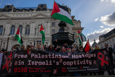 Pro Palestinian activists hold a banner during a demonstration at Piccadilly Circus in Central London. The activist group red ribbons demonstrated at Piccadilly Circus, London, urging the Israeli government to free Palestinian detainees following the recent conflict in Gaza.