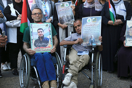 Palestinians with disabilities recently released from israeli prisons, hold portraits of their loved ones held inside Israeli jails during a demonstration in downtown Nablus in the West Bank, demanding their release. Palestinians gathered in downtown Nablus for a protest organized by prisoner advocacy groups and families calling for the release of relatives held in Israeli detention. The demonstration was prompted by recent developments concerning Palestinian prisoners and ongoing concerns over their treatment in Israeli military and civilian prisons.