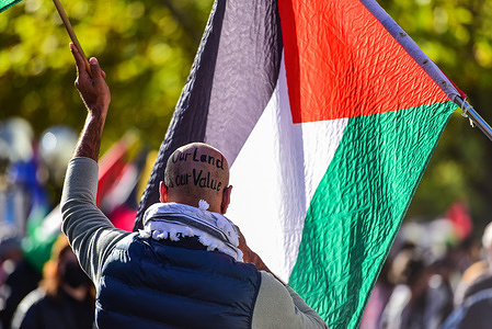 A protester with a sign on his head holds a flag during Nakba day Pro-Palestinian protest on St Kilda Road. A Nakba Day rally in Melbourne marked the 77th anniversary with participants marching approximately 6 kilometres from the State Library to St Kilda Beach. The demonstration included a protest outside the U.S. Consulate, denouncing U.S. support for Israel amid the ongoing conflict in Gaza. The rally expressed solidarity with the Palestinian struggle and called for justice and an end to Israeli occupation. Nakba Day commemorates the 1948 displacement of over 750,000 Palestinians during the creation of the state of Israel.