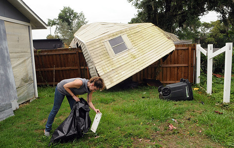 Elizabeth Ellis picks up debris after her shed and fence were destroyed, during the aftermath of Tropical Storm Cristobal.
A tornado spawned by Tropical Storm Cristobal passed through Orlando, Florida leaving at least 8 homes damaged by the EF1 tornado, along with numerous reports of downed trees and power lines. No injuries have been reported.