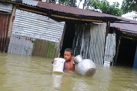 A child seen transferring some items from his submerged house to a shelter center in Sunamganj town area.
Flash floods, triggered by heavy rains and upstream water, have inundated Sunamganj town and 11 upazilas of the district, rendering thousands of people marooned.