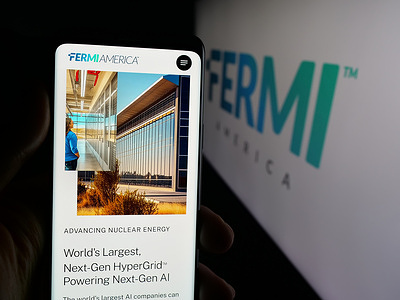 In this photo illustration, a person is holding a cellphone with the webpage of US energy development company Fermi America on screen in front of logo.