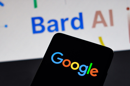In this photo illustration, the Google logo is displayed on a smartphone screen with the Google Bard AI logo in the background.