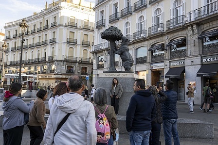 People are seen interacting near the “Bear and Strawberry Tree” monument near Puerta del Sol Square, located in the historic center of Madrid. As the political and cultural heart of Spain, Madrid is a city where imperial history and European modernity coexist. As the seat of government and key institutions, it is a hub of intense economic and social activity.
