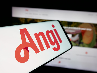 In this photo illustration, a smartphone with the logo of US online marketplace company Angi Inc. is seen on screen in front of website.