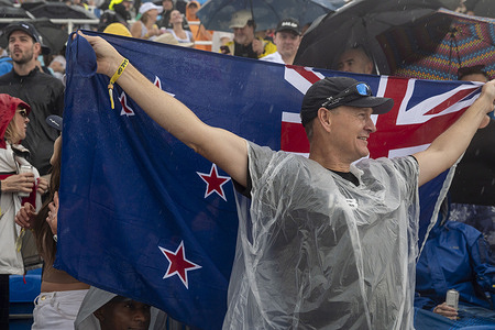 A spectator with flags New Zealand celebrates Team Australia BONDS Flying Roos SailGP boats wining on Day 1 of the Mubadala New York Sail Grand Prix at New York Harbor.
