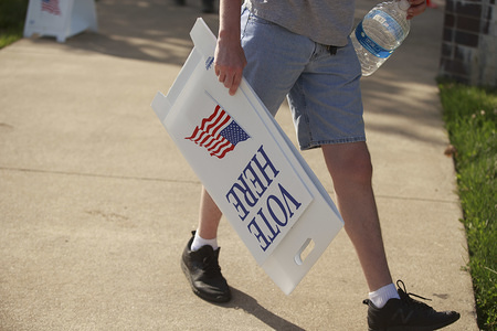 A worker is seen carrying "Vote Here" notices during election day in Indiana.
Primary Elections take place in Bloomington, Indiana after polls closed at Grandview Elementary School on Indiana Primary Election Day, June 2, 2020.