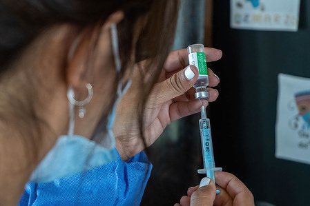 A nurse prepares a shot of India's Serum Institute Covishield vaccine against COVID-19 to be applied on elderly people in a makeshift care home at a special school.
The original care home inside San Martin Hospital was converted into the COVID-19 sector at the beginning of the pandemic and residents were transferred to a special school.