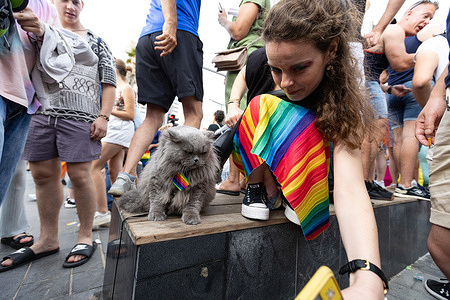 A woman with a rainbow skirt leans over to take selfie with a cat during the Tel Aviv LGBT Pride parade. Tel Aviv Pride 2023 was the last major, large-scale pride celebration before the traditional parade was disrupted by regional events. The 2023 parade was a massive success, drawing roughly 150,000 to 200,000 participants to celebrate along the Mediterranean promenade.