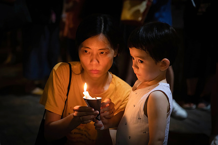 A mother and her son hold a lit candle in memory of the Tiananmen Massacre.
Amid covid-19 pandemic in Hong Kong, the Annual June 4 Vigil which was once a significant cornerstone for Hong Kong democratic environment, and has been held for 31 years has been put to a stop as police banned the event in 2020, and the organiser behind the vigil is facing disband.