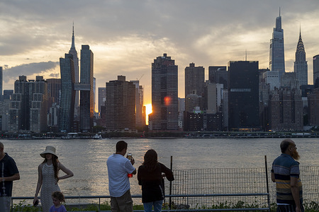 People watch the sunset on the summer solstice at Hunters Point South behind the skyline of midtown Manhattan and the Empire State Building. This Saturday at 2 hours 42 minutes UTC, according to calculations by the National Astronomical Observatory, the summer solstice will occur, a phenomenon in which the Sun reaches its maximum declination projecting its light over the maximum geographic latitude on Earth. This astronomical event starts the summer in the northern hemisphere and the winter in the southern hemisphere. In addition, the day of the summer solstice corresponds to the longest day of the year, since it is the day on which the Sun rises the earliest and the day on which it sets the latest.