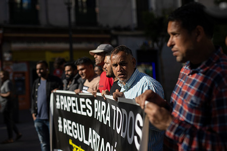 A group of people holds a banner during a demonstration called by anti-racist and migrant groups in Lavapiés, Madrid. The Valiente Bangla collective, made up of immigrants from Bangladesh, along with other migrant and anti-racist groups and organizations, called the mobilization to protest against the abuses, mafias, and racist governments that are profiting from the regularization of immigrants promoted by the government of Pedro Sánchez.