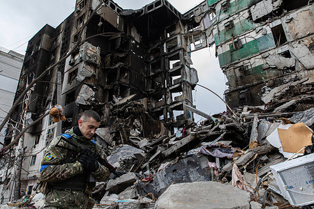A Ukrainian soldier walks past the ruins of a destroyed residential building. Following the recapture of Borodyanka by the Ukrainian forces, the city was heavily devastated and turned into ruins under intense fighting and shelling attacks.