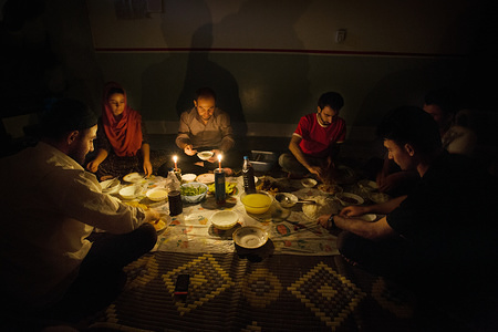A family sat at their dinner table during Ramadan; they are using a candle in order to bring light to the interior.
Electricity is one of the most critical problems Iraq is facing today. It has been one the weakest spots of Iraq’s infrastructure for a long time. In fact, as a result of the 2003 American attack on ousting Saddam Hussain’s regime, all Iraq's infrastructure suffered a lot, but it was electricity that has received the heaviest blow and this way has become the most difficult problem that Iraq’s nation and its government have to face.