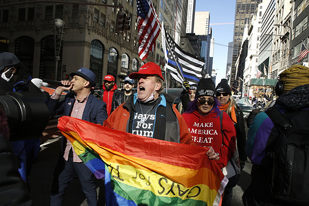 Trump supporters march towards Times Square holding up Trump and American Flags following a gathering in front of Trump Tower on Fifth Avenue.