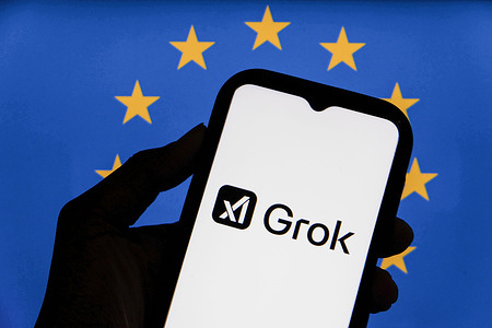In this photo illustration, the Grok logo, a generative artificial intelligence chatbot developed by US artificial intelligence company xAI seen displayed on a smartphone with the European Union flag in the background.