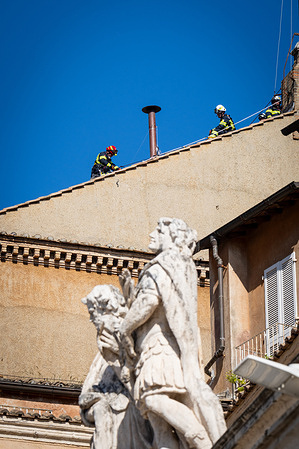 Firefighters install the chimney on the roof, at the Sistine Chapel where cardinals will gather to elect the new pope. Smoke will come out of the chimney announcing the choice of the new Pope.