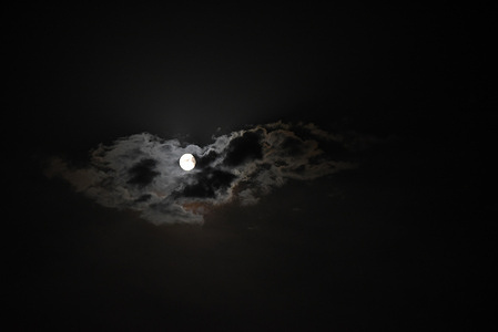 Sturgeon moon rises among the clouds in Rebollo de Duero, north of Spain.