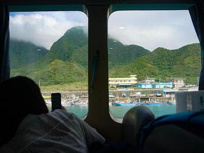 A ferry passenger seen taking photos of Orchid Island. Orchid Island (Lanyu), also known as Pongso no Tao (“island of human beings”), is a volcanic island near the southeastern coast of Taiwan. A volcanic island is an island that is formed by eruptions of volcanoes on the ocean floor. The island has been a home to the aboriginal, Tao people.