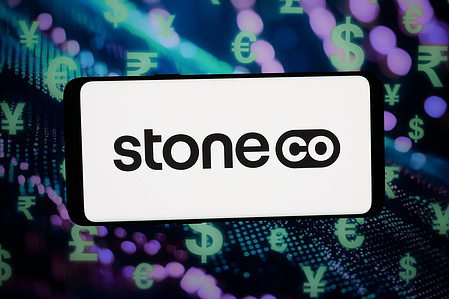In this photo illustration, the logo of financial technology company StoneCo Ltd. is displayed on a smartphone in front of abstract background on computer screen.
